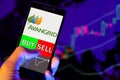 Company logo Avangrid Inc AGR on smartphone screen, hand of trader holding mobile phone showing BUY or SELL on background of sto