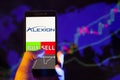 Company logo Alexion Pharmaceuticals, Inc ALXN on smartphone screen, hand of trader holding mobile phone showing BUY or SELL on Royalty Free Stock Photo