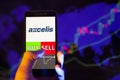 Axcelis Technologies, Inc. ACLS on smartphone screen, hand of trader holding mobile phone showing BUY or SELL on background of s