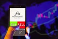 Company logo First Majestic Silver Corp AG on smartphone screen, hand of trader holding mobile phone showing BUY or SELL on back