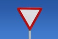 Give way, traffic or transit sign, white triangle and reds on a pole against a blue sky