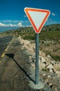 YIELD traffic signpost on roadside and rocky landscape Royalty Free Stock Photo