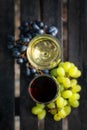 Yin Yang sign made from wine and grapes. Glasses of red and white wine and grapes on a wooden table outdoor Royalty Free Stock Photo
