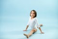 8yo girl in a white leotard doing splits, looking at the camera. Royalty Free Stock Photo