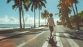 16YO teenager boy on longboard moving down the street under palm trees to the beach under summer suN. Modern active teenslifestyle