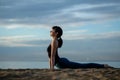 Yoga asana outdoors on beach. up facing dog pose Royalty Free Stock Photo