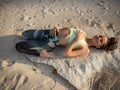 Yoga on the beach. Beautiful woman lying on the sand, practicing Supta Virasana Reclining Hero Pose. Slim body. Healthy spine. Royalty Free Stock Photo