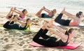 Yoga on beach, group of females practicing