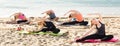 Yoga on beach, group of females training