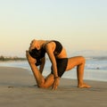 Yoga on the beach. Variation of Low Lunge Pose, Anjaneyasana. Lunging back bending asana. Flexible spine and back. Healthy Royalty Free Stock Photo