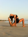 Yoga on the beach. Variation of Low Lunge Pose, Anjaneyasana. Lunging back bending asana. Flexible spine and back. Healthy Royalty Free Stock Photo