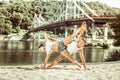 Young female and male doing acrobatic yoga exercise