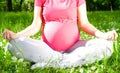 Yoga, Beautiful pregnant woman relaxing in the park. Royalty Free Stock Photo