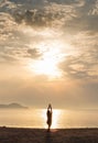 At sunrise by the sea, women practice yoga