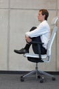 Yoga on chair in office - business man exercising