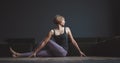 Yoga class. A beautiful, trained body. Woman makes an asana against a dark background in a city apartment. Body beauty