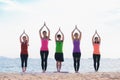 Yoga class at sea beach in evening ,Group of people doing namaste poses with relax emotion Royalty Free Stock Photo