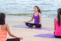 Yoga class at sea beach in evening sunset ,Group of asia people Royalty Free Stock Photo