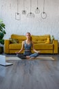 Yoga classes at home. A slender gray woman in a tracksuit is sitting in front of a laptop