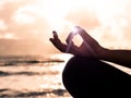 Closeup woman hand practicing lotus pose on the beach at sunset Royalty Free Stock Photo