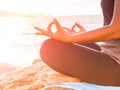 Closeup woman hand practicing lotus pose on the beach at sunset Royalty Free Stock Photo