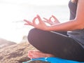 Yoga concept. Closeup woman hand practicing lotus pose on the beach at sunset Royalty Free Stock Photo