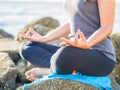 Yoga concept. Closeup woman hand practicing lotus pose on the beach at sunset Royalty Free Stock Photo