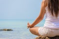 Yoga concept. Closeup woman hand practicing lotus pose on the beach Royalty Free Stock Photo