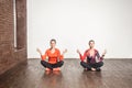 Yoga concept. Two cute woman sit in lotus pose and meditating