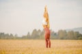 Yoga concept. Young woman dawn performs workout in park, yellow grass field