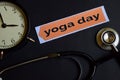 Yoga Day on the print paper with Healthcare Concept Inspiration. alarm clock, Black stethoscope.