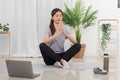 Yoga exercise concept, Young Asian woman in lotus position while doing yoga exercise online at home Royalty Free Stock Photo