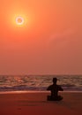 Yoga exercises at ocean sunset. Man's silhouette.