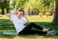 Yoga and fitness. Portrait of young woman in sports clothes, sitting performs an exercise, doing sports in the Park on the grass. Royalty Free Stock Photo