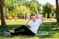 Yoga and fitness. A young woman in sports clothes, sitting performs an exercise, doing sports in the Park on the grass Royalty Free Stock Photo