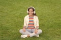 Yoga girl. small kid in headphones. summer playlist. enjoy spring nature outdoor. child study audio book. new technology Royalty Free Stock Photo