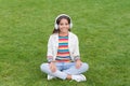 Yoga girl. small kid in headphones. summer playlist. enjoy spring nature outdoor. child study audio book. new technology Royalty Free Stock Photo