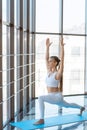 Yoga girl in warrior pose indoor. Beautiful woman in white sportswear doing yoga. Royalty Free Stock Photo