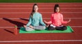 Yoga gives energy. teenage girls practicing yoga on mat outdoor. meditation. be in harmony with body. fitness warming up Royalty Free Stock Photo
