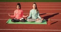 Yoga gives energy. teenage girls practicing yoga on mat outdoor. meditation. be in harmony with body. fitness warming up Royalty Free Stock Photo