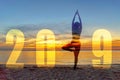 Yoga Happy new year card 2019. Silhouette lifestyle woman practicing yoga standing as part of Number 2019 near the beach at sunset Royalty Free Stock Photo