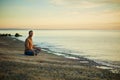 Yoga heals the soul. a man sitting in the lotus position during his yoga routine at the beach.