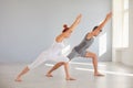 Yoga for health. A man and a woman in sportswear are practicing yoga in a bright classroom. Royalty Free Stock Photo