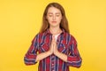 Yoga, inner peace and harmony. Portrait of happy calm ginger girl in checkered shirt praying with closed eyes