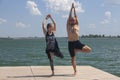 Yoga inspiration. Top view - couple of cheerful healthy beautiful slim man and woman are doing virabhadrasana Royalty Free Stock Photo