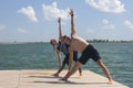 Yoga inspiration. Top view - couple of cheerful healthy beautiful slim man and woman are doing virabhadrasana Royalty Free Stock Photo