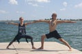 Yoga inspiration. Top view - couple of cheerful healthy beautiful slim man and woman are doing virabhadrasana Royalty Free Stock Photo