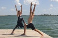 Yoga inspiration. Top view - couple of cheerful healthy beautiful slim man and woman are doing virabhadrasana Royalty Free Stock Photo