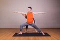 Yoga instructor correcting student performing Warrior 2 or Virabhadrasana 2