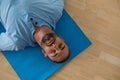 Yoga instructor exercising while lying on mat in yoga studio Royalty Free Stock Photo